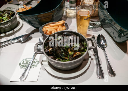 Moules Marinières et Frites; Muscheln mit Pommes frites, serviert im Restaurant Chez Léon in Brüssel, Belgien. Stockfoto