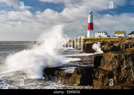 Eine Welle bricht auf den Felsen in der Nähe von Portland Bill Leuchtturm an der Jurassic Coast of Dorset zum UNESCO-Weltkulturerbe Stockfoto