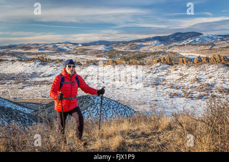 ältere männliche Wanderer erreichen oben auf einem Hügel am Fuße der Rocky Mountains - Winterlandschaft Stockfoto