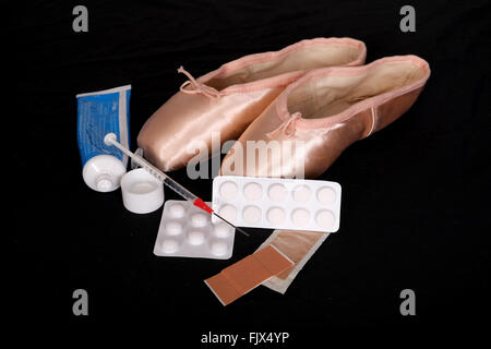 Schmerzen für die Leistung, paar Ballerinas Pointe Pumpen mit Pillen, Lotionen, klebrige Putze & eine Spritze 3. März 2016 Stockfoto