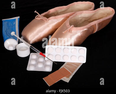 Schmerzen für die Leistung, paar Ballerinas Pointe Pumpen mit Pillen, Lotionen, klebrige Putze & eine Spritze 3. März 2016 Stockfoto