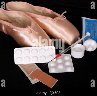 Schmerzen für die Leistung, paar Ballerinas Pointe Pumpen mit Pillen, Lotionen, klebrige Putze & eine Spritze 3. März 2016 Stockfoto