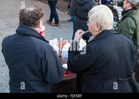 Die Menschen Essen und Trinken in der Öffentlichkeit. Ein paar Snacking auf mitnehmen Essen und Trinken, Nottingham, England, Großbritannien Stockfoto