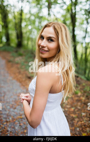 Schöne blonde Frau in weißem Kleid Stockfoto