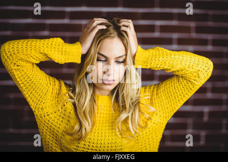 Schöne blonde Frau hält ihren Kopf Stockfoto