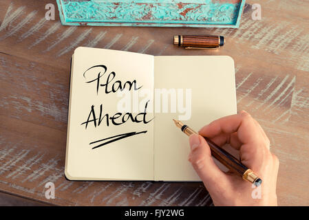 Retro-Effekt und getönten Bild einer Frau hand schreiben eine Notiz mit einem Füllfederhalter auf einem Notebook. Handgeschriebener Text voraus planen, als Firmen-Konzept-image Stockfoto