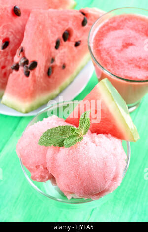 Wassermelone-Sorbet in Glasschüssel auf grünem Hintergrund Stockfoto