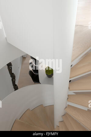 No-Nonsense, moderne Wohnung in Kopenhagen. Weiße Wände und einen Holzboden. Kunstwerke und minimalistischen Stil. Wendeltreppe. Stockfoto