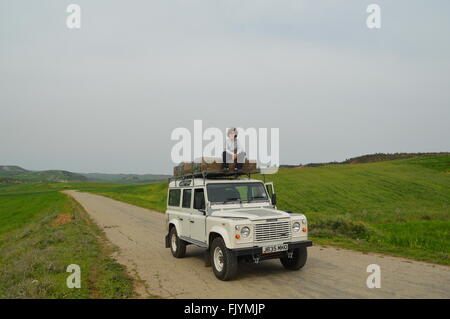 Junge sitzt auf Top Land Rover Stockfoto