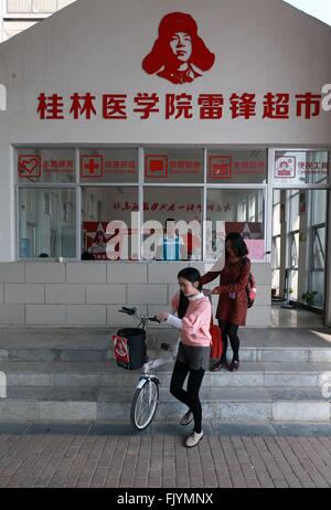 (160304)--GUILIN, 4. März 2016 (Xinhua)--zwei Studenten leihen Fahrräder von einem Lei Feng-Supermarkt auf dem Lingui Campus der Guilin Medical University in Guilin, Süd-China Autonome Region Guangxi Zhuang, 4. März 2016. Lei Feng, ein junger chinesischer Soldat in den 1960er Jahren ist bekannt, für fast alle seine Freizeit und Geld selbstlos Bedürftigen zu widmen. Er starb, nachdem er von einem fallenden Mast und hilft einem Kameraden einen LKW auf 15. August 1962 direkt getroffen. Lei Feng Tag fällt am 5. März jeden Jahres. Lei Feng Supermarkt an Guilin Medical University, eröffnet im November o Stockfoto