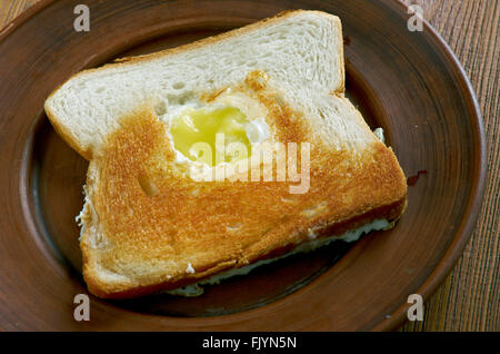 Ei im Korb - Ei in ein Loch mit einem Stück Brot gebraten. Stockfoto