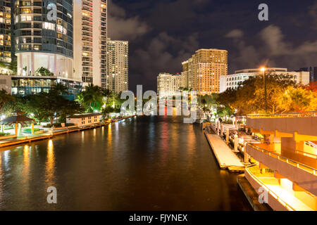 Nachtansicht des New River mit Riverwalk Promenade Eigentumswohnung Hochhäuser und Yachten in Fort Lauderdale, Florida, USA Stockfoto