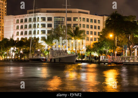 Nachtansicht des New River mit Yachten, Riverwalk Promenade und Eigentumswohnungen in der Innenstadt von Fort Lauderdale, Florida, USA Stockfoto