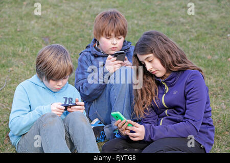 Kinder spielen mit ihren smartphones Stockfoto