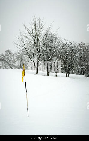 Golfflagge auf dem Platz im Schnee Stockfoto