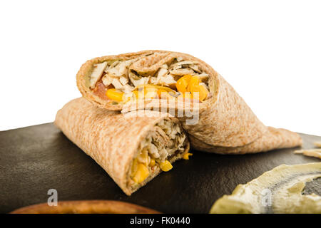 Sandwich-Wrap oder Tortilla mit Fleischresten, Käse, Schweinefleisch und Mais auf Schneidebrett über weiß schwarz. Leckeres Fast Food, Mexikanisch Stockfoto
