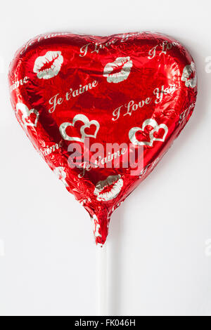 Ich liebe dich, je t'aime solide Milch Schokolade Herz lolly für Valentinstag geformt auf weißem Hintergrund, ideal für Valentinstag, Valentinstag Stockfoto