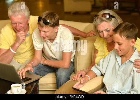 Familie sitzt mit laptop Stockfoto