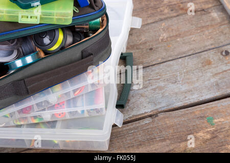 Angeln und Köder in Box und Tasche auf Holzbrettern Hintergrund für Outdoor-aktive Geschäftstätigkeit Stockfoto