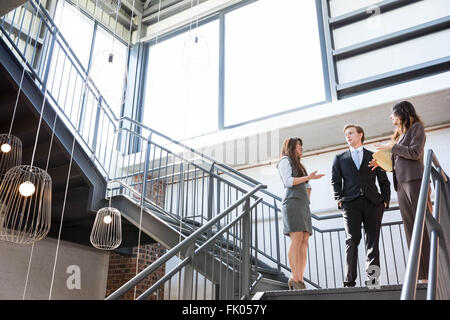 Drei Führungskräfte stehen auf einer Treppe Stockfoto