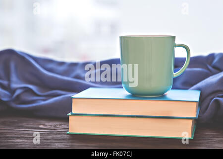 Tasse warmes Getränk auf den Stapel Bücher Stockfoto