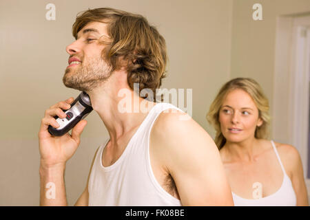 Hübscher Mann mit seiner Freundin hinter rasieren Stockfoto