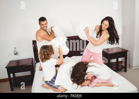 Fröhliche Familie Kissen kämpfen auf Bett Stockfoto