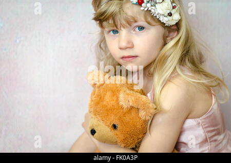 Porträt von schönen blonden Mädchen mit nach Hause Hand gemacht Stirnband und Teddybär Spielzeug Stockfoto