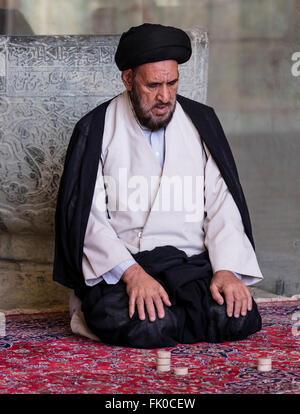 Schiitische Muslime Mullah im Turban und Kleid sitzt beim Gebet in der Masjed-e Jame (Freitagsmoschee), Isfahan, Iran Stockfoto