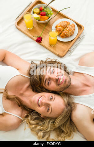 Nettes Paar im Bett neben einem Frühstückstablett Stockfoto