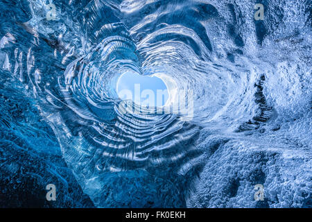 Durch eine Öffnung in einer Eishöhle in Island nachschlagen Stockfoto