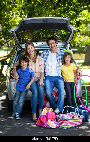 Lächelnd Familie sitzen in den Kofferraum Stockfoto