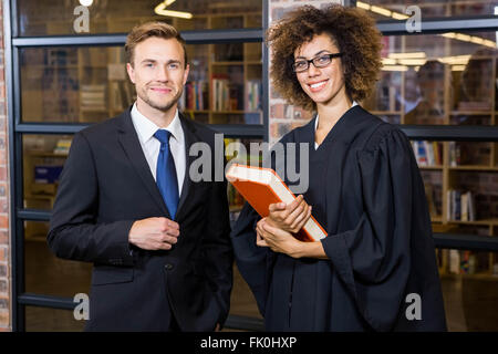 Geschäftsmann, stehend mit Rechtsanwalt Library in der Nähe Stockfoto