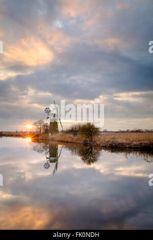 Turf Moor Mühle spiegelt sich in den ruhigen Gewässern des Flusses Ant at wie Hügel wie die Sonne durch die Wolken bricht. Stockfoto