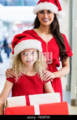 Mutter und Tochter in Weihnachten Kleidung ansehen mit Weihnachtsgeschenke Stockfoto