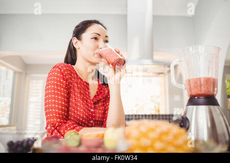 Lächelnde Frau trinken Fruchtsaft Stockfoto