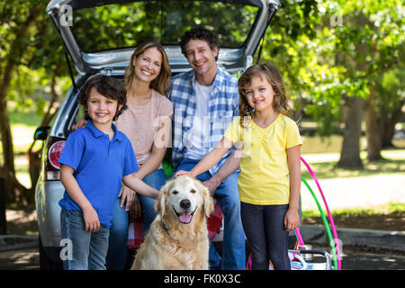 Lächelnde Familie vor einem Auto Stockfoto