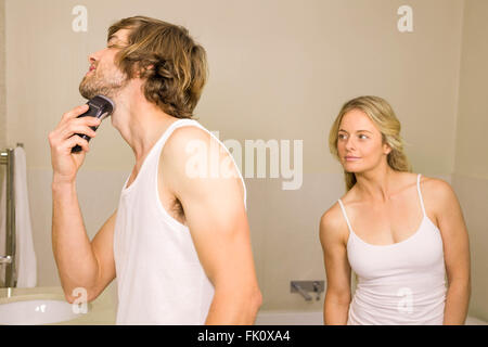 Hübscher Mann mit seiner Freundin hinter rasieren Stockfoto