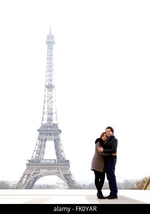 Jung und in Liebe Brünette Pärchen vor Eiffelturm, Paris, Trocadero mit Blick auf die Stadt während des Tages - umarmt Stockfoto