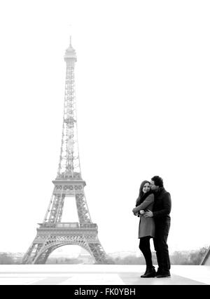 Jung und in Liebe Brünette Pärchen vor Eiffelturm, Paris, Trocadero mit Blick auf die Stadt während des Tages - umarmt Stockfoto