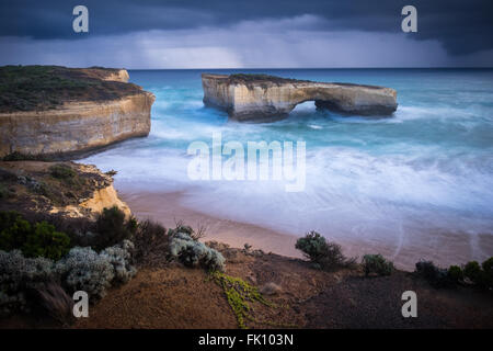 Regen-Duschen-Pass der landschaftliche Bogen Naturgebilde, London Bridge (Bogen), in der Nähe von Port Campbell entlang der Great Ocean Road in Victoria. Der Bogen war einmal mit dem Festland durch eine Steinbrücke verbunden, die unerwartet am 15. Januar 1990 stürzte, zwei Menschen gestrandet auf dem äußeren Stapel verlassen, die später mit dem Hubschrauber gerettet werden konnten. Stockfoto