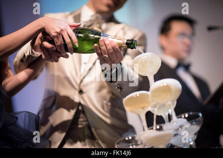 Singapur, 9. Januar 2016: neue Brautpaar Gießen Champagner in Gläser am Bankett Empfang. Stockfoto