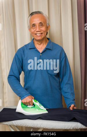 Glücklich senior asiatischen Mann Hausarbeit zu genießen. Stockfoto