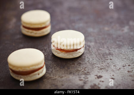 Drei Macarons mit Caramell füllen Stockfoto