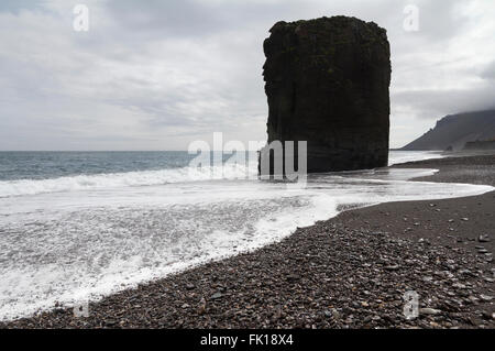 Horizontale Ansicht von einem isländischen Strand mit einer riesigen Felsformation in der Mitte Stockfoto