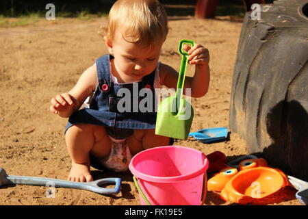Babymädchen spielen im sand Stockfoto