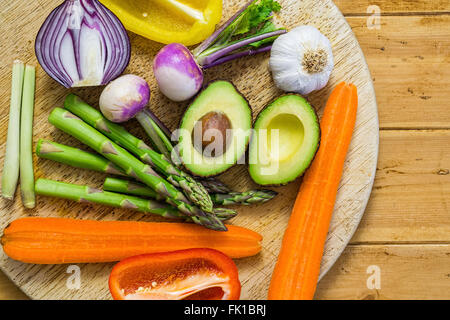 Frisches Gemüse in Scheiben geschnitten auf einem Holztisch, Rundweg, Spargel, Avocado, Paprika, Zwiebel Stockfoto