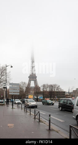 Belebte Straße in Paris an einem nebligen Morgen Januar. Eiffel-Turm im Hintergrund. Stockfoto