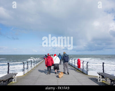 Saltburn von Meer, North Yorkshire, England, UK, 5. März 2016. Wetter: gut eingepackt spazieren Samstag auf Saltburn viktorianischen Pier wie ein eisiger Wind der kalten Nordsee bläst. Bildnachweis: Alan Dawson News/Alamy Live-Nachrichten Stockfoto