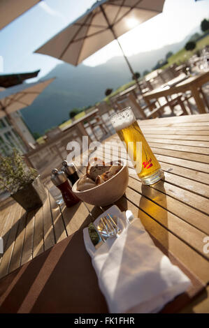 Haben Sie ein Bier auf der Terrasse im Grand Tirolia Golf und Ski Resort. Kitzbühel. Tirol. Österreich Stockfoto